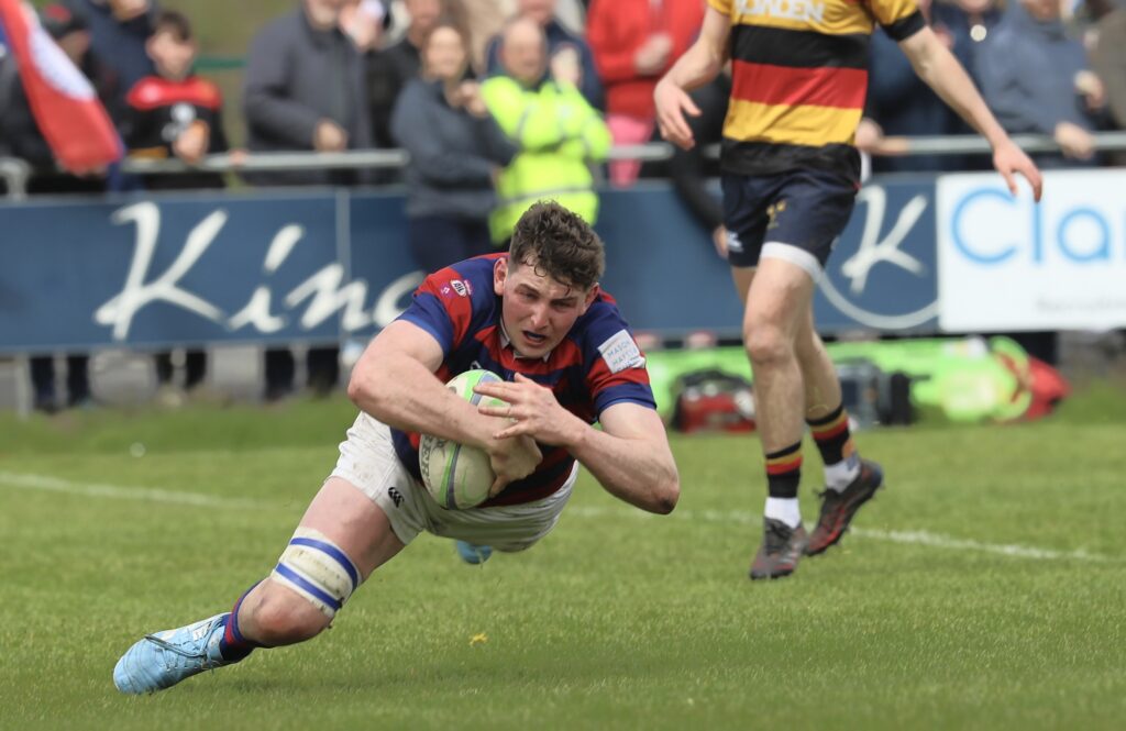 Clontarf winger Fionn Gilbert dives over to score the opening try during Clontarf’s 39–28 victory over Lansdowne FC at Castle Avenue